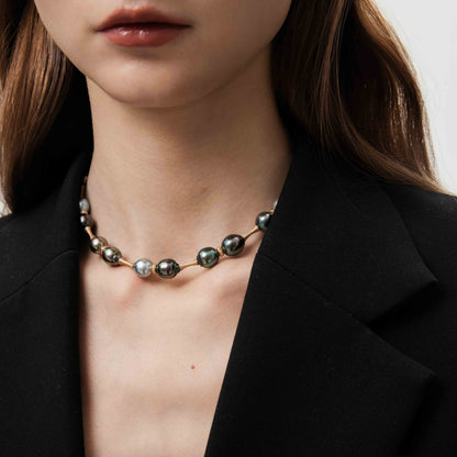 Necklace with beads worn by a person in a black blazer.