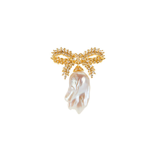 Gold bow-shaped brooch with a pearl on a white background