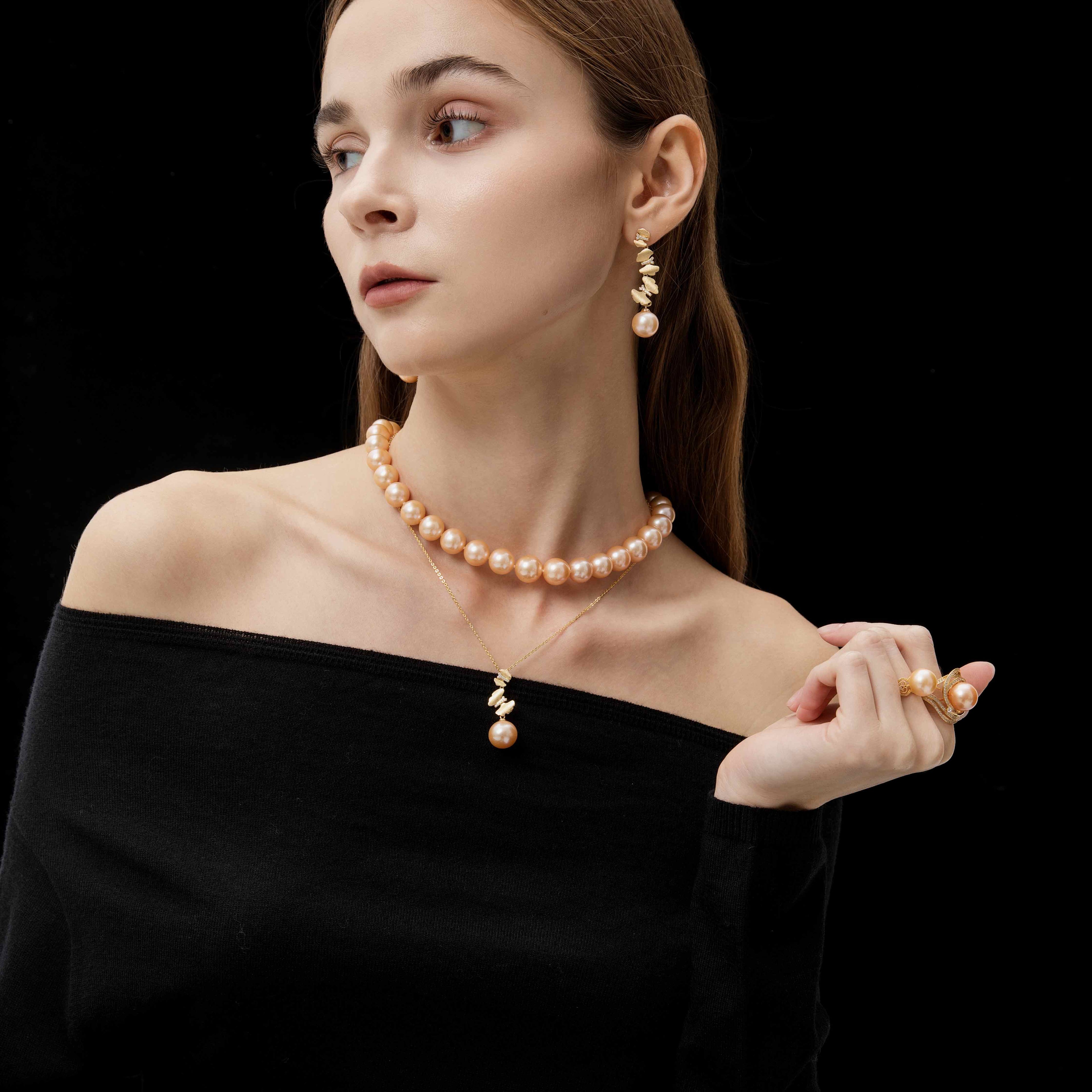 Woman wearing a butterflies pearl necklace and earrings on a black background