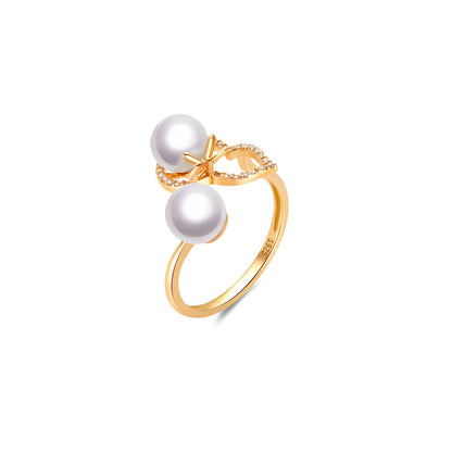 Gold ring with two pearls on a white background