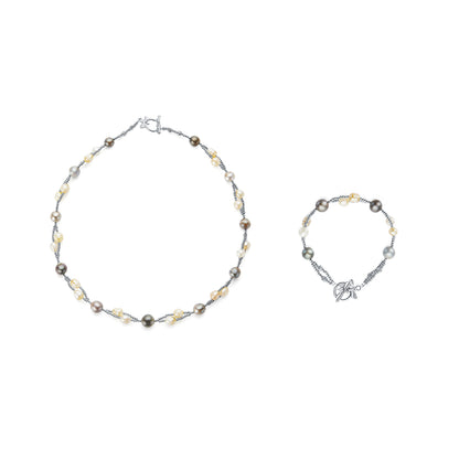 Necklace and bracelet set with pearls and silver accents on a white background
