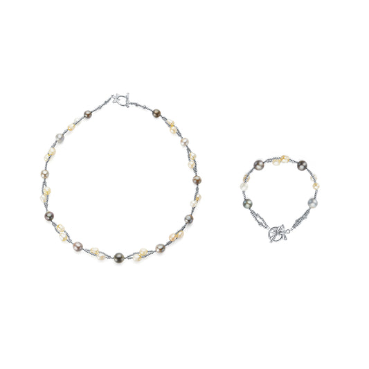 Necklace and bracelet set with pearls and silver accents on a white background