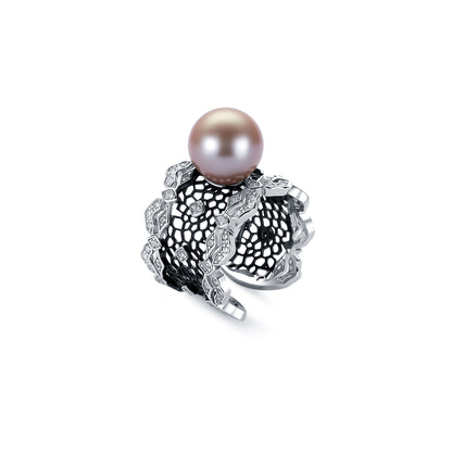 Pearl ring with intricate silver design on a white background