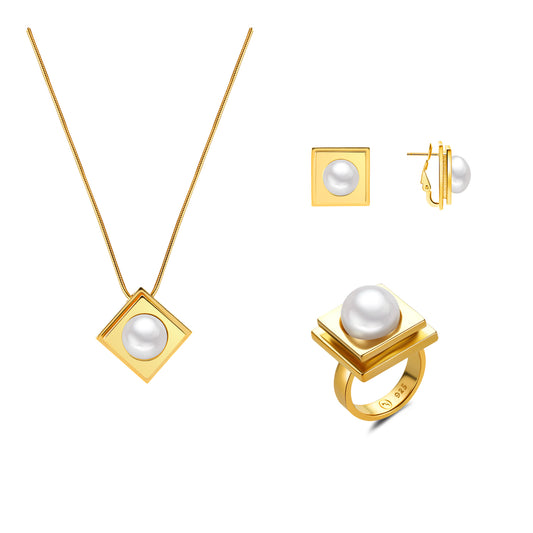 Gold jewelry set with pearls including a necklace, ring, and earrings on a white background.