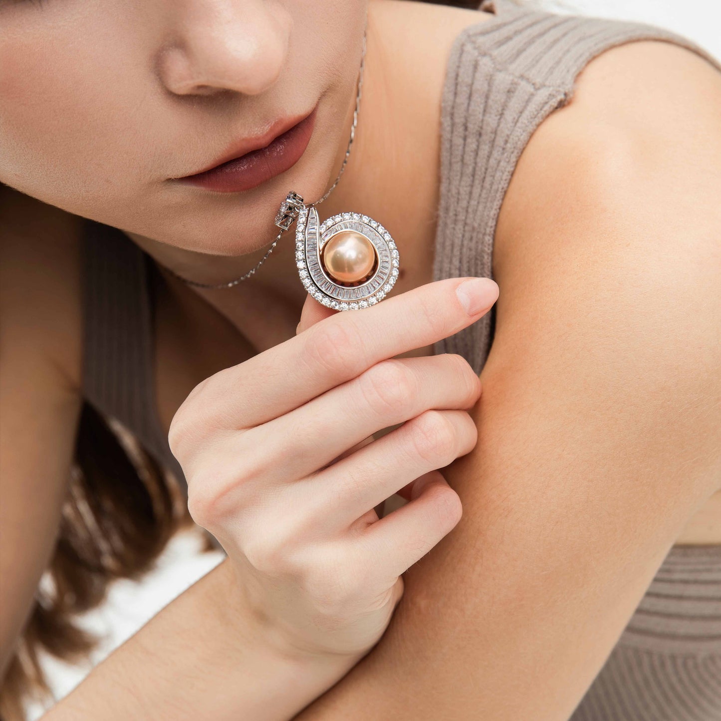 Close-up of a woman wearing a pearl necklace with a blurred background