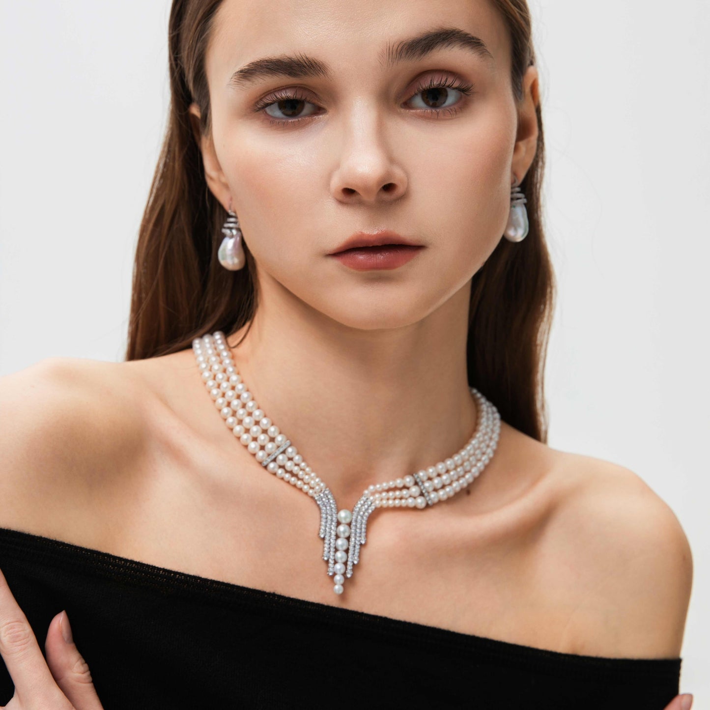 Woman wearing a 3-Strand Pearl Necklace with Sterling Silver and Gemstones and earrings