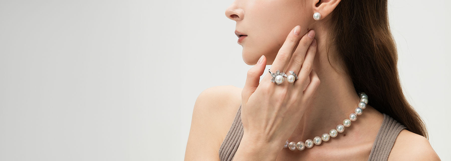 A woman model wearing pearl earrings, pearl rings and pearl necklace.